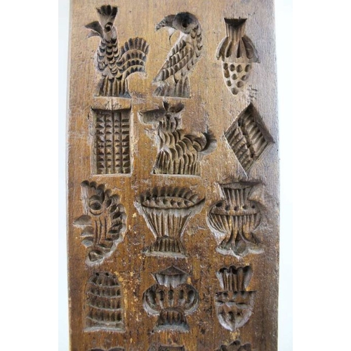 131 - A 19th century Dutch gingerbread mould, many small designs, include a cockerel, heart, barrel, boot,... 