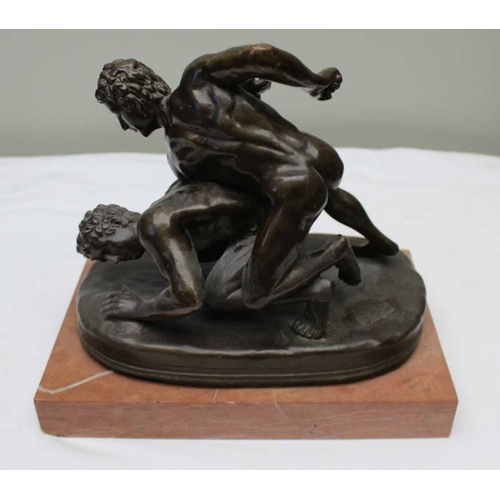 135 - After the Antique, Bronze wrestlers, mounted upon a rouge Antico polished marble base, 24cm high