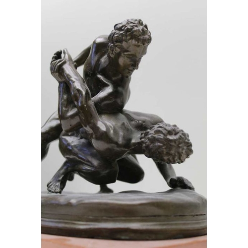 135 - After the Antique, Bronze wrestlers, mounted upon a rouge Antico polished marble base, 24cm high