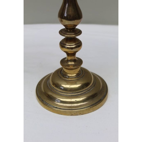 141 - A pair of 19th century brass candlesticks, with broad drip pans, 27cm high