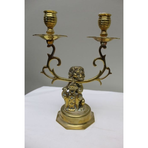 143 - A pair of 19th century Dutch brass twin branch candlesticks, the stem cast as a lion supporting the ... 