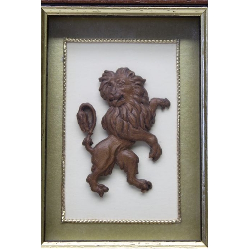 157 - A late 19th century German pressed leather lion, framed, together with a pair of brass & oak candles... 