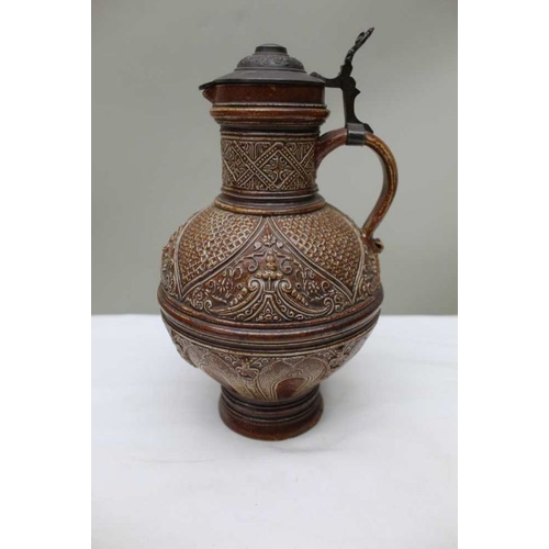 164 - A German moulded stoneware jug, with hinged pewter cover, c.1900, 27cm high