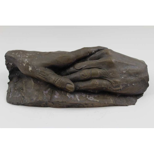 175 - A bronze effect cast resin sculpture of clasped hands, 25cm long