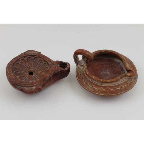 179 - Two terracotta items of Ancient Roman form, comprising an oil lamp and a small jug, the lamp is 8cm ... 