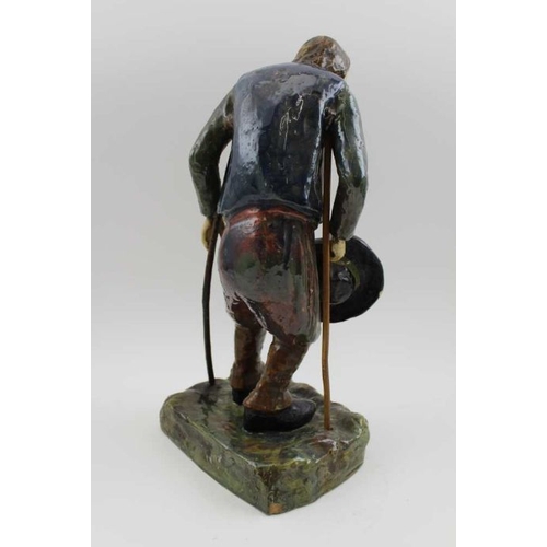 186 - A Continental glazed earthenware figure of a peasant on crutches, c.1900, monogram to base and the n... 