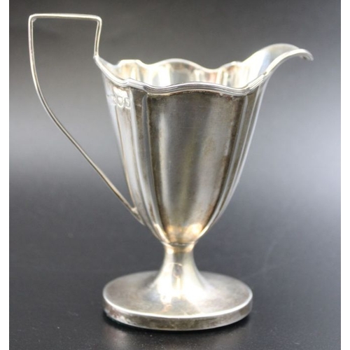 24 - Thomas Bradbury & Sons, a late 19th century silver cream jug of tapering fluted form, weighted oval ... 