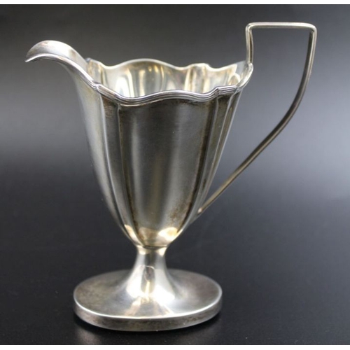 24 - Thomas Bradbury & Sons, a late 19th century silver cream jug of tapering fluted form, weighted oval ... 