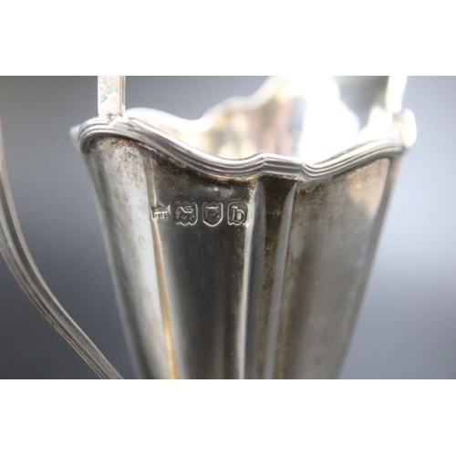 24 - Thomas Bradbury & Sons, a late 19th century silver cream jug of tapering fluted form, weighted oval ... 