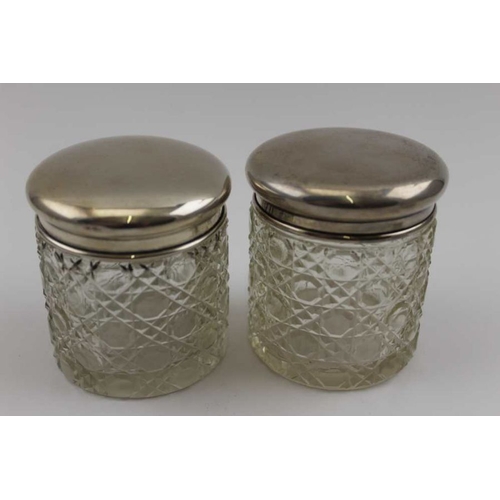 26 - Three silver lidded cut glass dressing table jars, one being a hair tidy (two match Birmingham 1925)... 