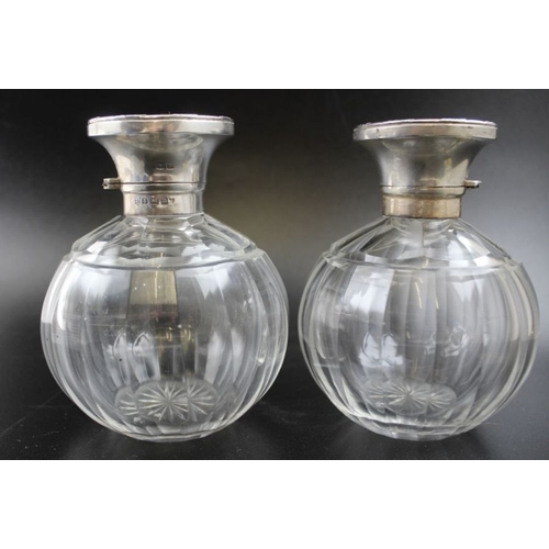 32 - William Neale, a pair of early 20th century silver lidded facet cut globular scent bottles, having s... 