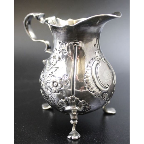 37 - A George II silver cream jug, repousse floral decoration, scroll handle, raised on three trefoil sup... 