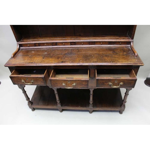 375 - A George III oak dresser, with plate rack back, a run of small drawers above the base fitted three d... 