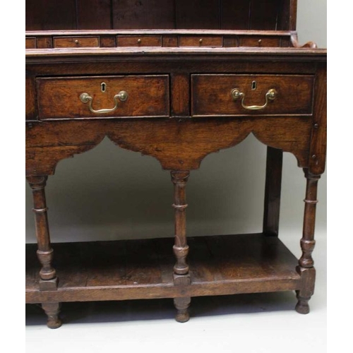 375 - A George III oak dresser, with plate rack back, a run of small drawers above the base fitted three d... 