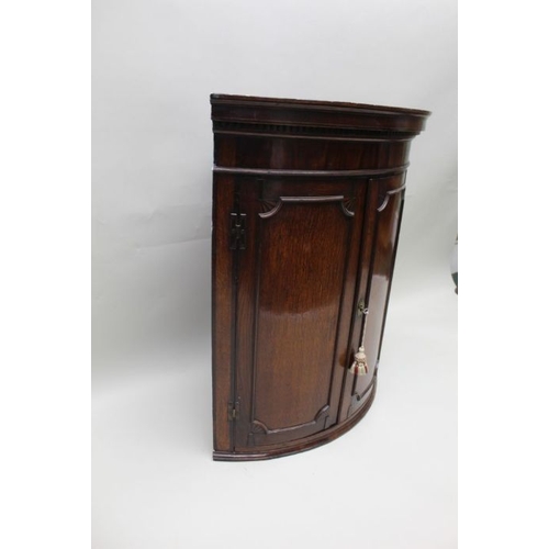 391 - A George III oak bow front hanging corner cupboard, with dentil cornice and mahogany inlay, 91cm hig... 