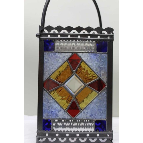 409 - An Edwardian multi-coloured stained glass lantern within a metal frame, 30cm high