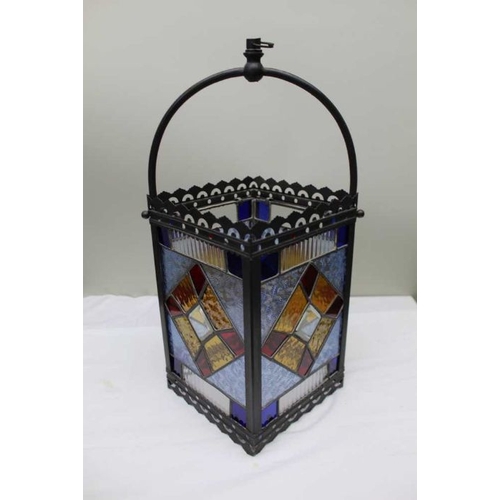 409 - An Edwardian multi-coloured stained glass lantern within a metal frame, 30cm high