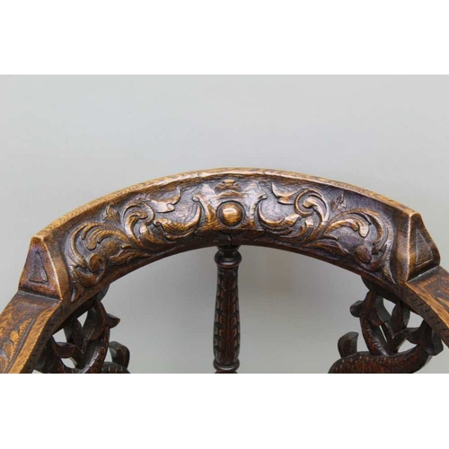 413 - A Victorian 17th century design oak corner chair with carved horse shoe crest on double dolphin supp... 