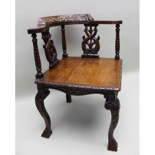 413 - A Victorian 17th century design oak corner chair with carved horse shoe crest on double dolphin supp... 