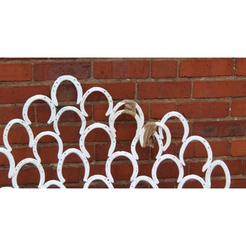 445 - A suite of garden furniture constructed from welded horseshoes, comprising two chairs, and a pair of... 