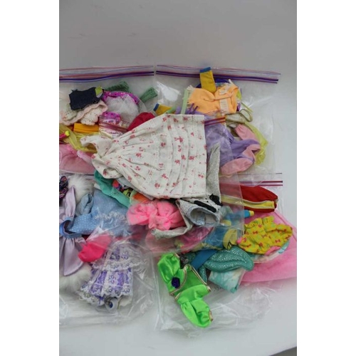 463 - A large collection of dolls clothes, a Baywatch model jet ski, two model play horses