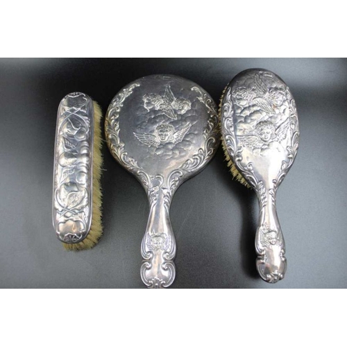 77 - William Neale, An Edwardian embossed silver mounted hand vanity mirror, embossed angel decoration, C... 