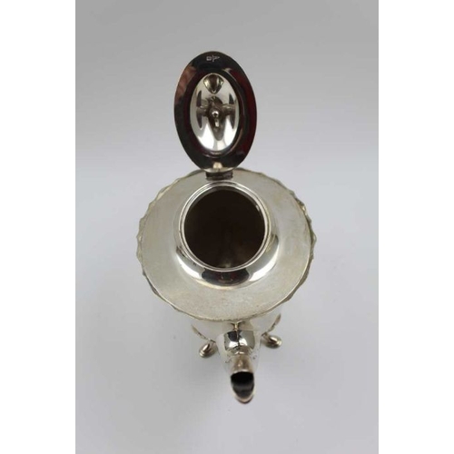 12 - Walker & Hall, A silver teapot, shaped rim, hinged cover, raised on four hoof feet, Sheffield 1914, ... 