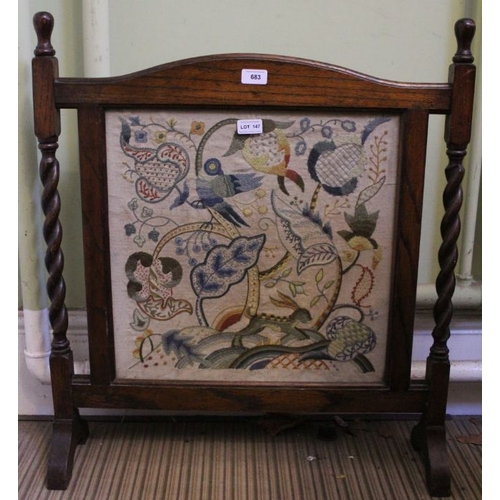 147 - An oak framed tapestry fire screen on barley twist supports. 67cm wide.