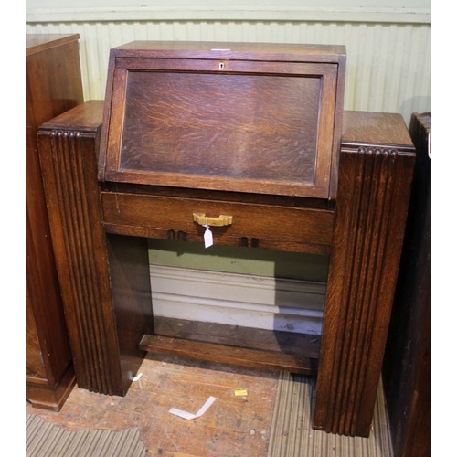 186 - An art deco design oak desk having fall down front over single drawer supported on twin ribbed uprig... 