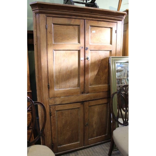 221 - A rustic wooden corner cupboard having two pairs of plain cupboard doors. Shelved interior 183 cm hi... 