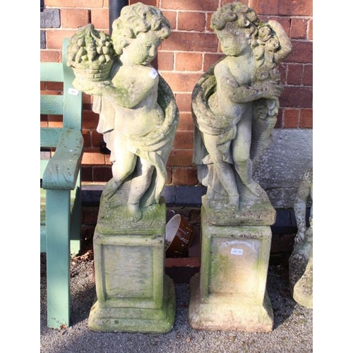 317 - A pair of well weathered garden cherubs on square pedestal plinths. 107 cm high.