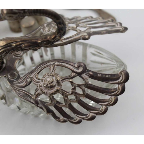 48 - A silver mounted cut glass swan with articulated wings, a similar smaller one, various scent bottles... 