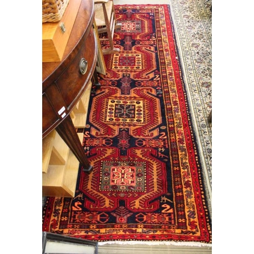 147 - An Azerbaijan woven long rug, four central motifs in a multi-ground border, 290cm x 110cm