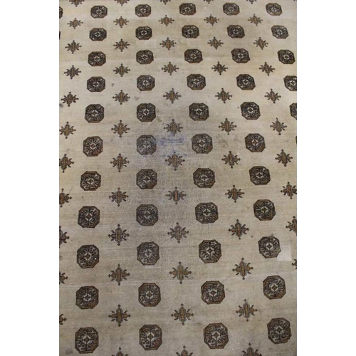 200 - A large room sized biscuit ground floor rug. With multi elephants foot decorated central field withi... 