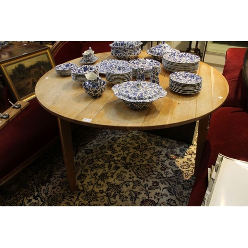 215 - A large oak plank topped circular table, supported on three plain block legs