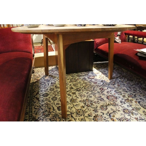 215 - A large oak plank topped circular table, supported on three plain block legs