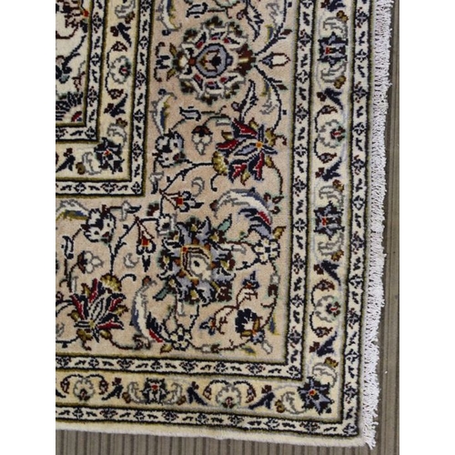 228 - A Persian Kashan woven woollen carpet, floral design field on pale ground, 350cm x 245cm