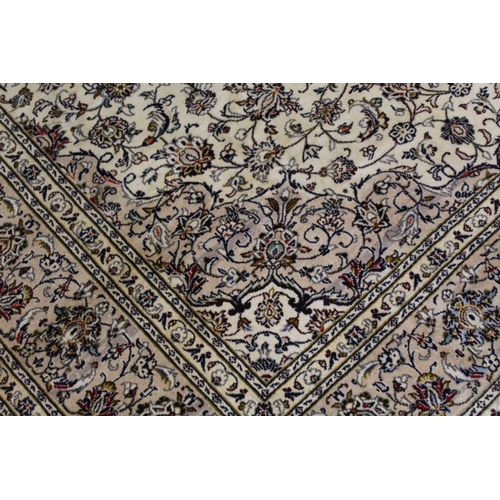 228 - A Persian Kashan woven woollen carpet, floral design field on pale ground, 350cm x 245cm