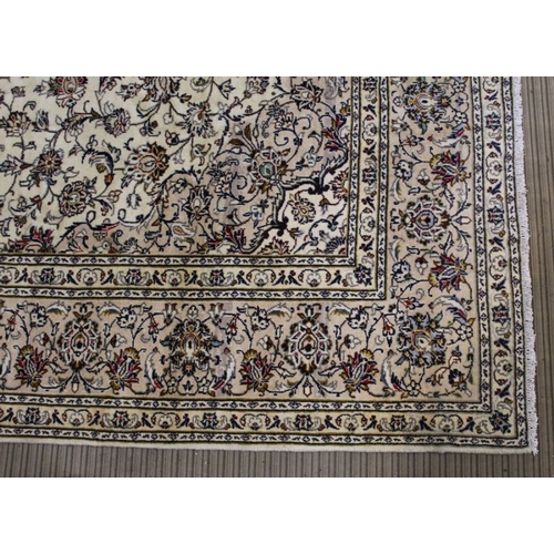 228 - A Persian Kashan woven woollen carpet, floral design field on pale ground, 350cm x 245cm