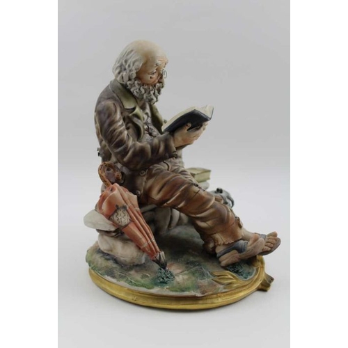 48 - A Capodimonte ceramic figure, a tramp reading, 24cm