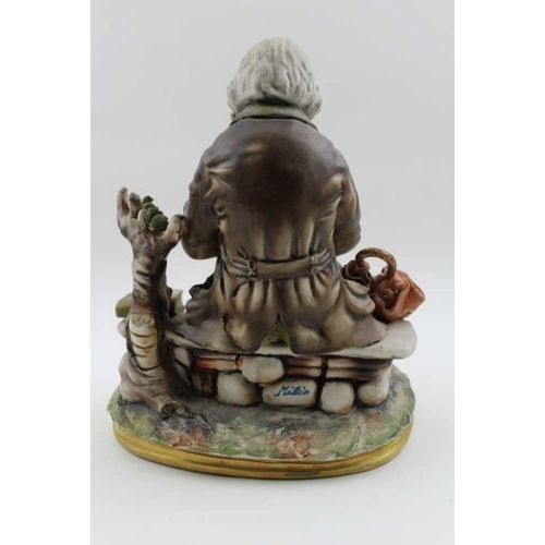 48 - A Capodimonte ceramic figure, a tramp reading, 24cm