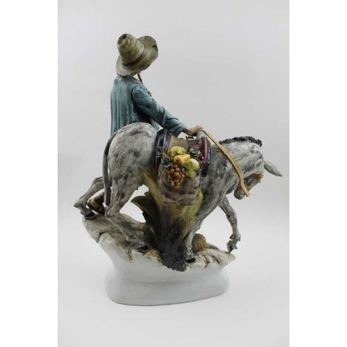 49 - A Capodimonte ceramic figure of a man with his donkey, the pannier full of fruit, 39cm