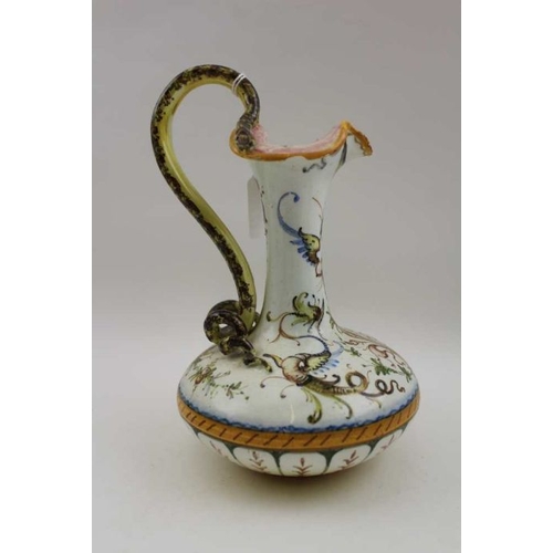 68 - An Italian majolica ewer form jug with painted decoration and serpent handle, together with a simila... 