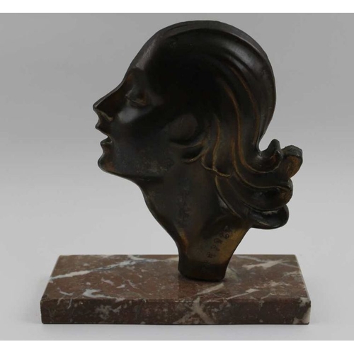 74 - An Art Deco ornament, formed as a cast metal profile of a young woman, inscribed 