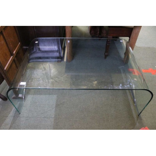 142 - A large glass coffee table, 110cm x 40cm