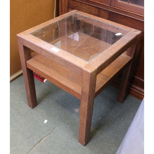 227 - A modern square topped table, glass insert panel, over solid magazine undertier