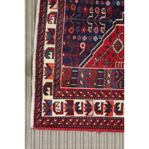 267 - A Persian Shiraz woven woollen carpet, busy blue and red central field 2.95m x 2.10m