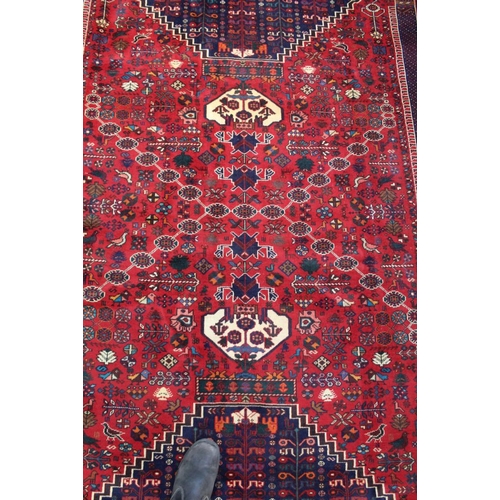 267 - A Persian Shiraz woven woollen carpet, busy blue and red central field 2.95m x 2.10m