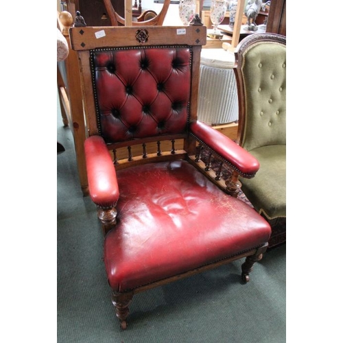 128 - A late 19th century oak gothic revival open armed library chair. With buttoned red leather upholster... 