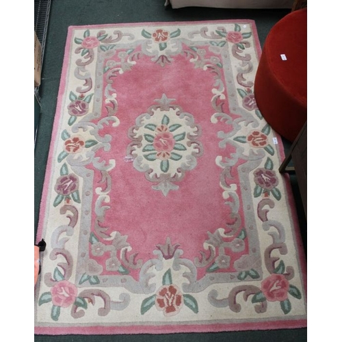 135 - A pink ground Chinese washed wool floor rug, 122cm x 183cm